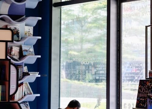 free-photo-of-a-man-reading-a-book-in-front-of-a-large-window