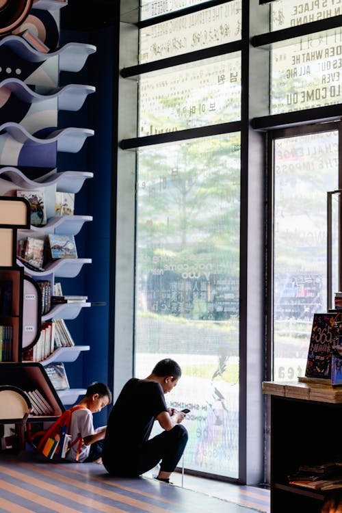 free-photo-of-a-man-reading-a-book-in-front-of-a-large-window